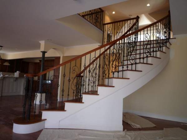 Красивая лестница из бетона с коваными перилами в интерьере частного дома