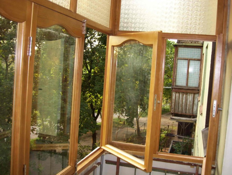 Открытая створка деревянного окна на балконе
