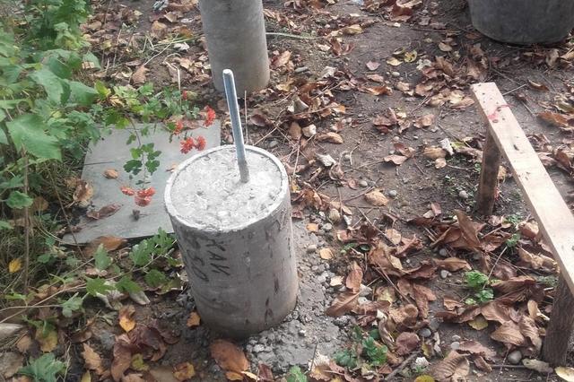 Одна из опор – асбестоцементная труба, залитая бетоном. Хорошо виден закладной арматурный прут для последующей связи с обвязкой.