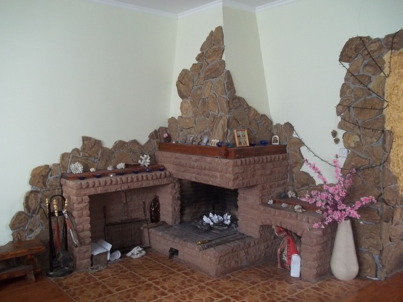 Угловой камин на снимке декорирован двумя видами керамогранита