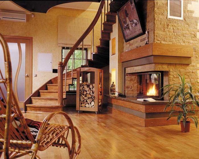 Интерьер гостиной с камином и лестницей в деревянном доме